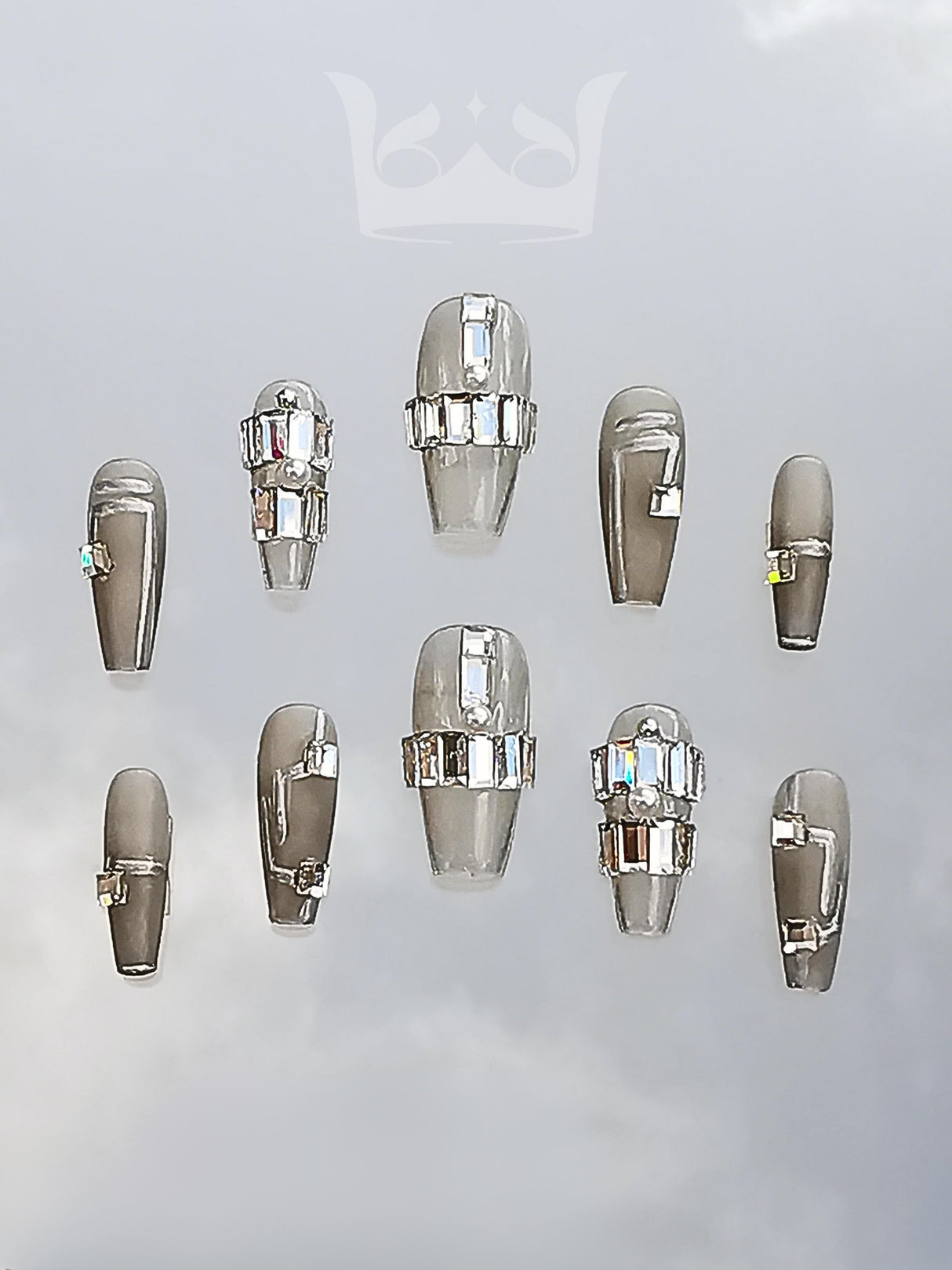 Bold and glamorous nails with metallic silver/chrome base, rhinestone embellishments, accent nails, and glossy finish for special occasions/events.