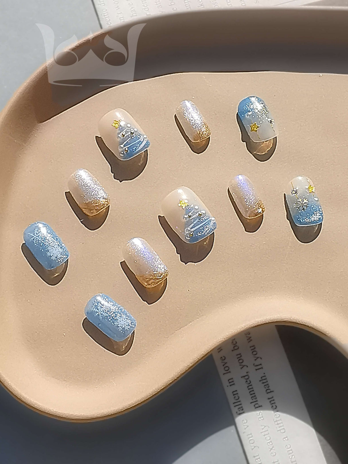 These press-on nails are a fashion accessory with a celestial or night sky theme, featuring a gradient effect, sparkle, glitter, star accents, rhinestone embellishments, and a glossy finish