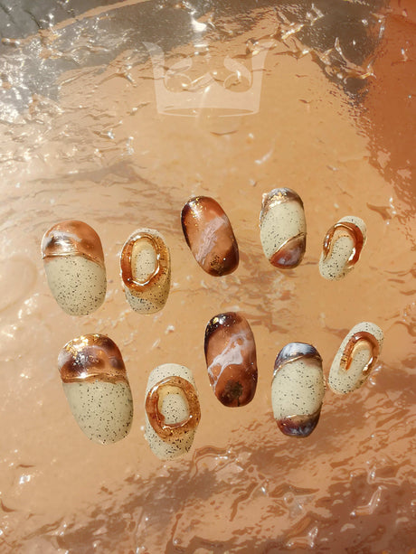Oval medium-length press-ons with hand-painted marble effect. Painted with a netruel color pallate and stone-like background. Best nail art design in 2024.