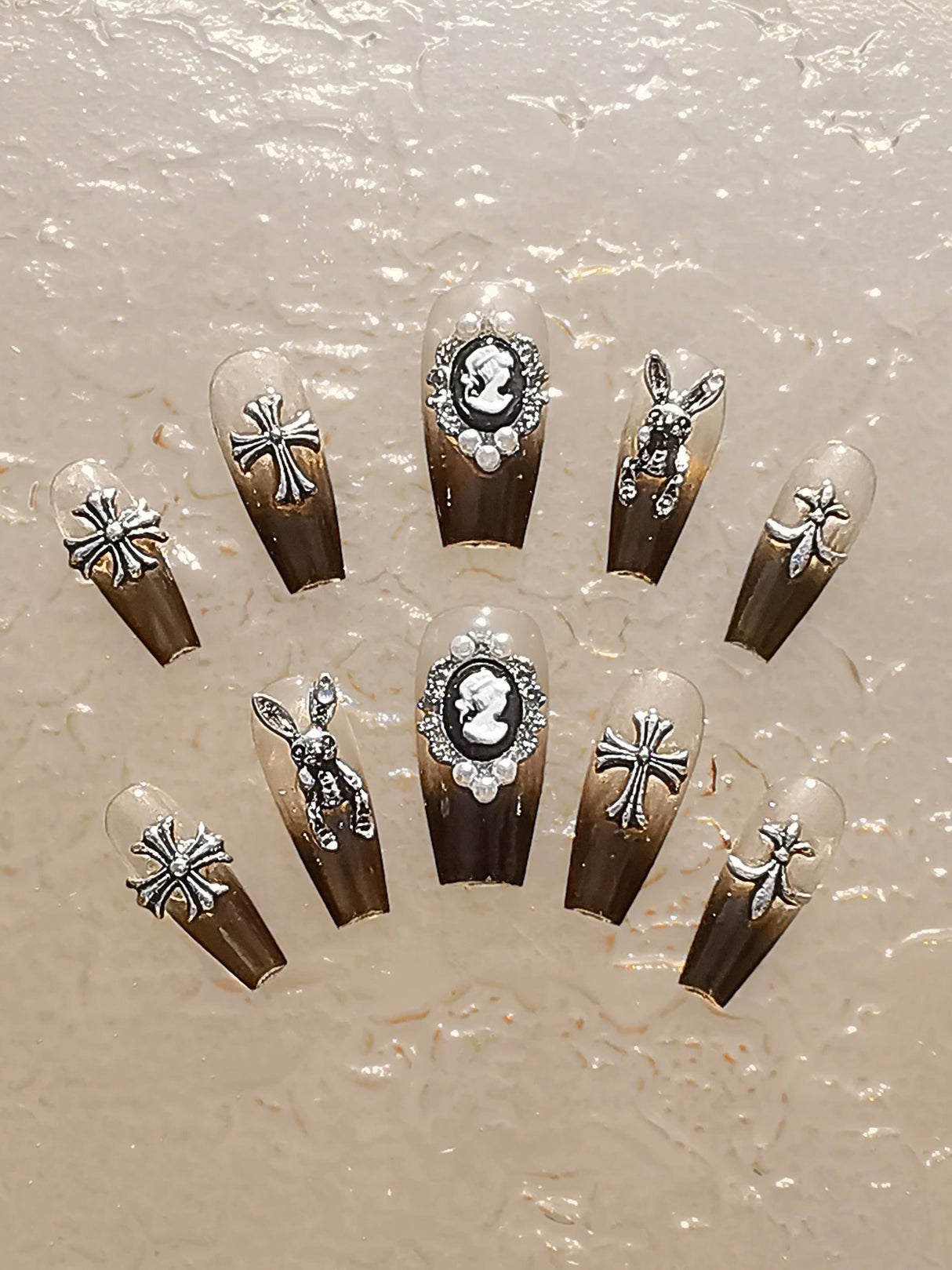 Elaborate nails with vintage and gothic influence, featuring silver glitter, rhinestones, and metallic details. Suitable for special occasions and bold fashion statements.