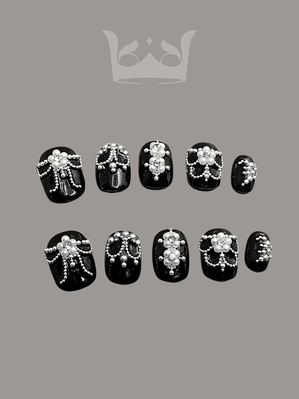 Luxury nails with black base color, white pearls, and clear crystals arranged in different patterns for an elegant look at formal events.