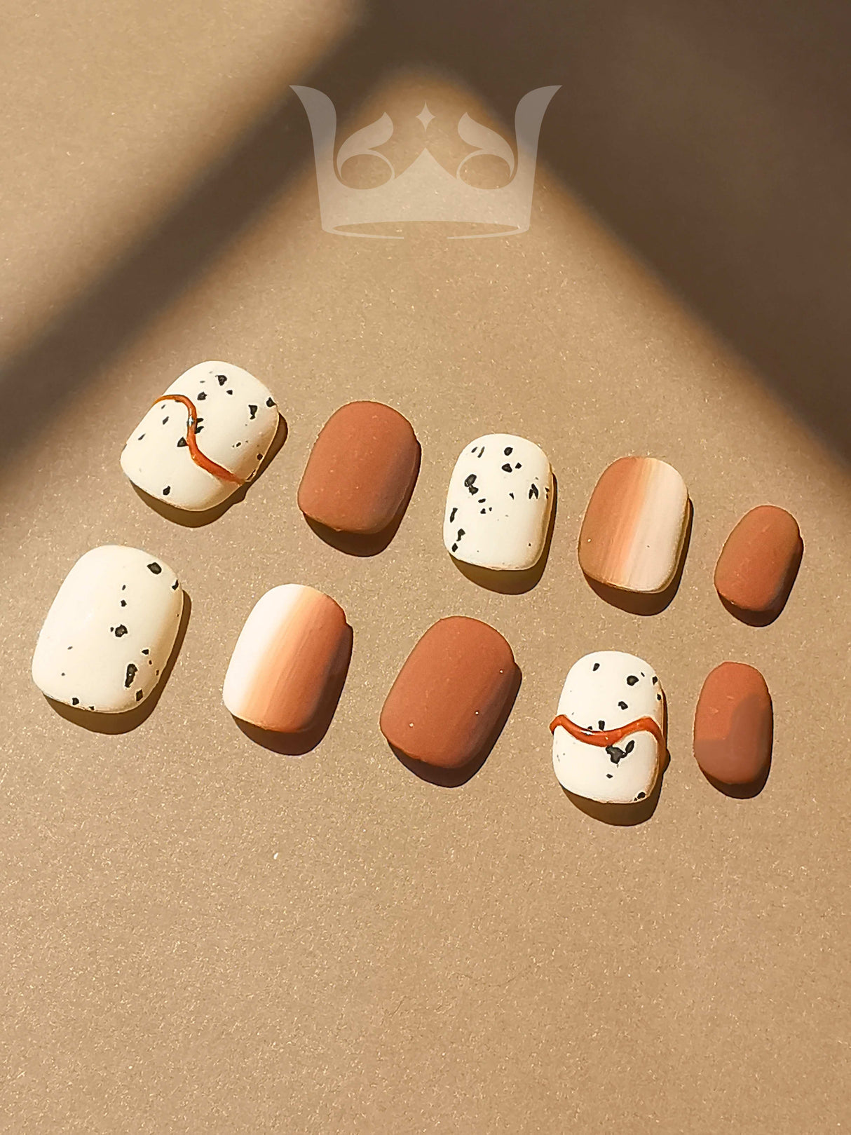Minimalist and modern nails with neutral colors and simple patterns suitable for various occasions and outfits. Includes solid colors, speckled pattern, and abstract lines in earthy tones.
