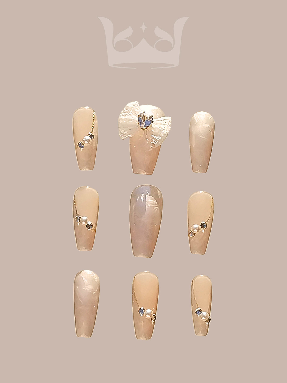 Sophisticated nails with nude base color, small shiny embellishments, flower-like design with jewel, and consistent rounded/oval shape for formal/luxurious occasions.