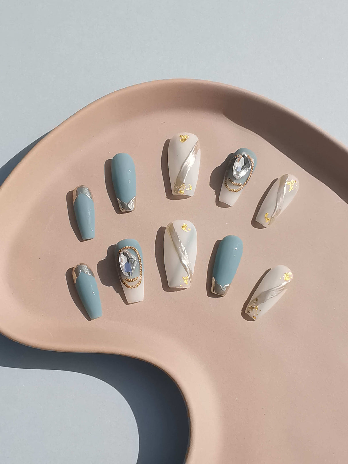 These press-on nails feature pastel colors, matte finish, golden accents, and diamonds. They appeal to those who want to make a statement and stay up-to-date with fashion trends.
