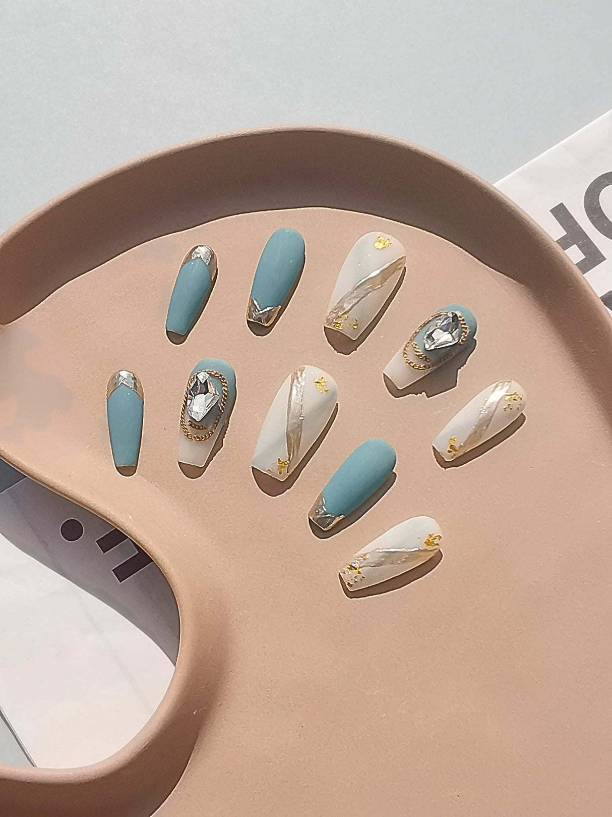 These trendy nails includes gold foil accents, star decals, and gemstone embellishments, and they come with a soft pink or peach tray for display.
