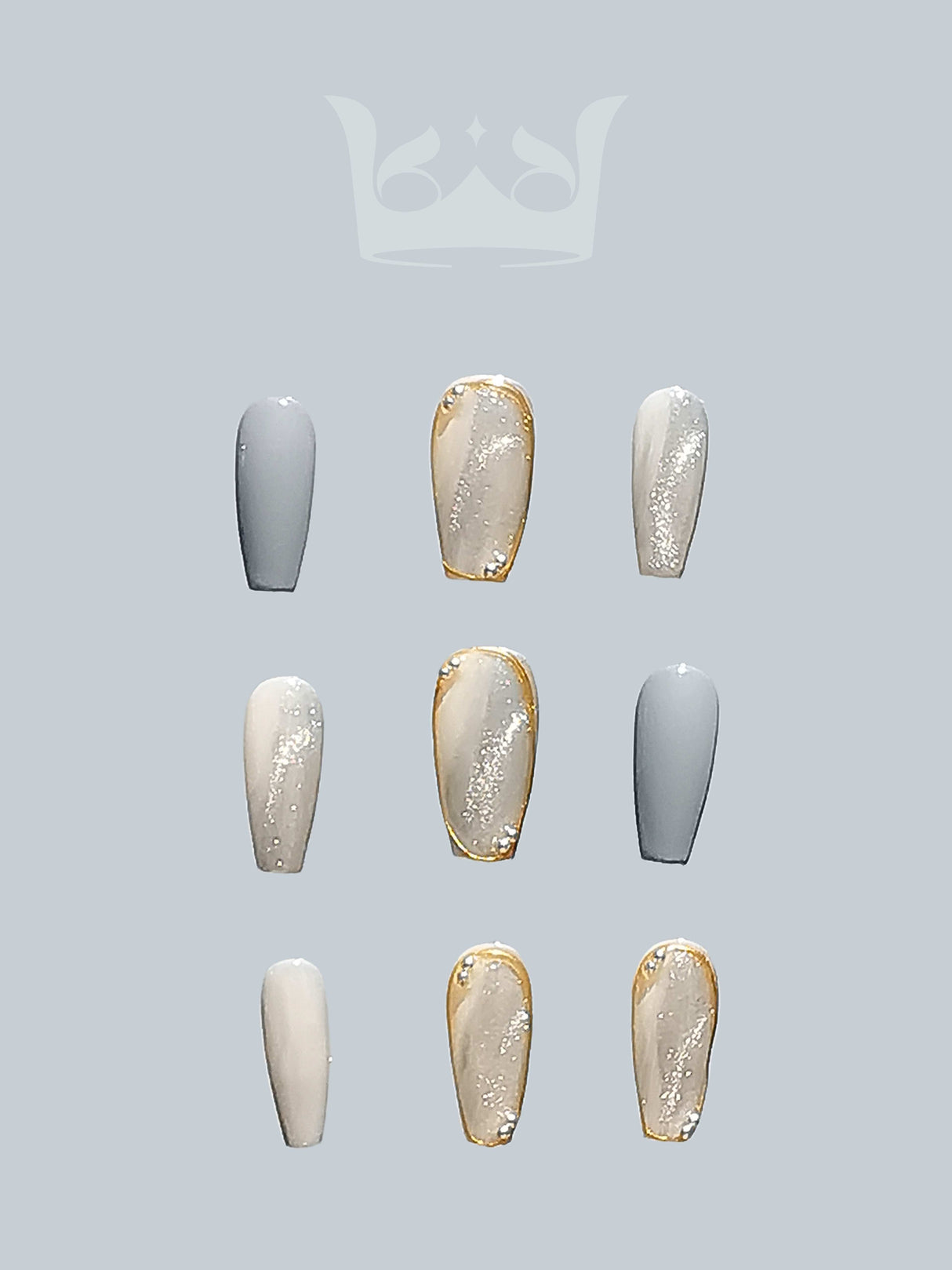 These acrylic nails come in varying lengths and shapes with a cool-toned gray and creamy color scheme, gold foil accents.