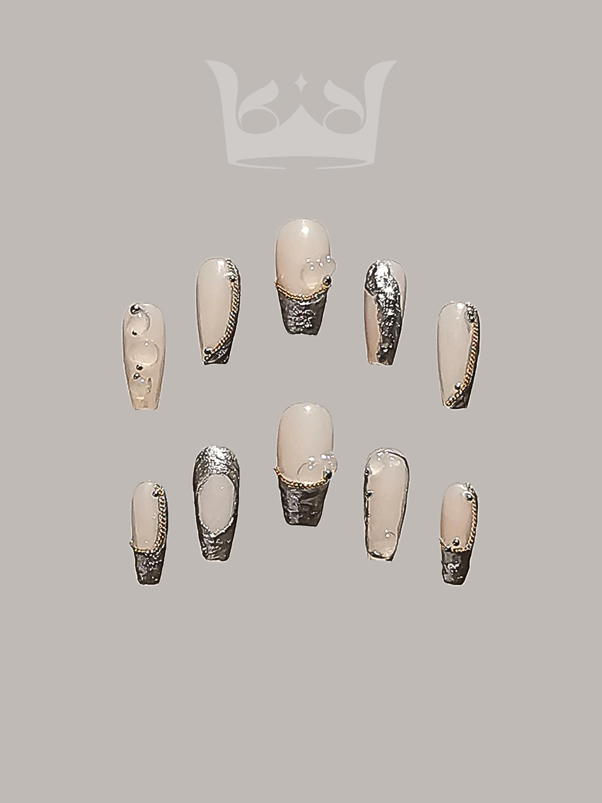 Fashionable and elegant nails with nude/neutral base color and metallic silver accents, designed for special occasions or fashion statements. Trendy and fancy.
