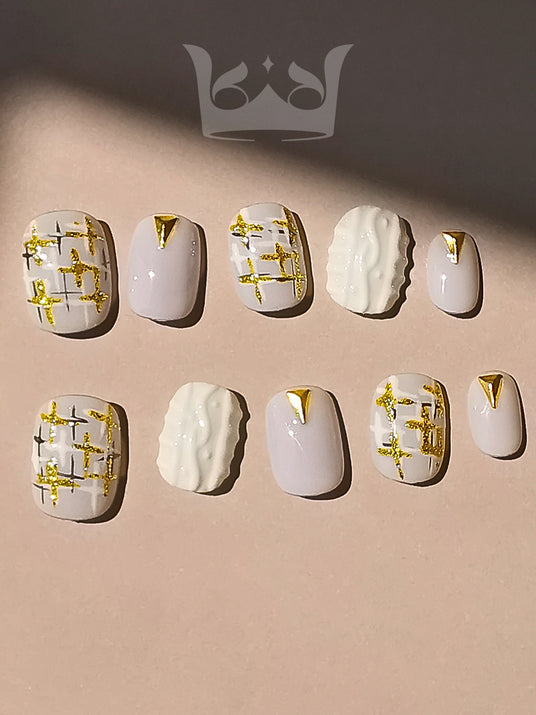 These press-on nails are perfect for a special occasion, featuring a pastel purple base with gold geometric patterns and a textured accent nail for a chic and fancy look.