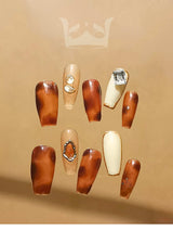 These stylish nails feature a warm, earthy color scheme with diamonds and unique designs, perfect for making a bold fashion statement or special occasion.