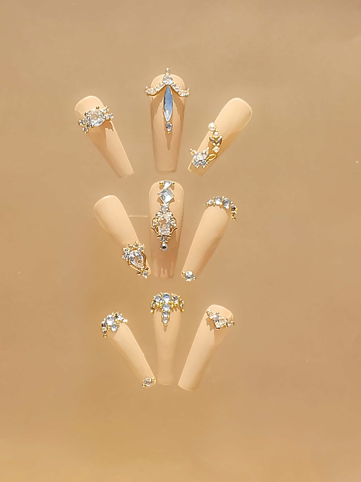 Luxurious and glamorous nails with trendy handcrafted nail art, incorporating rhinestones and crystals in different patterns, suitable for special occasions.
