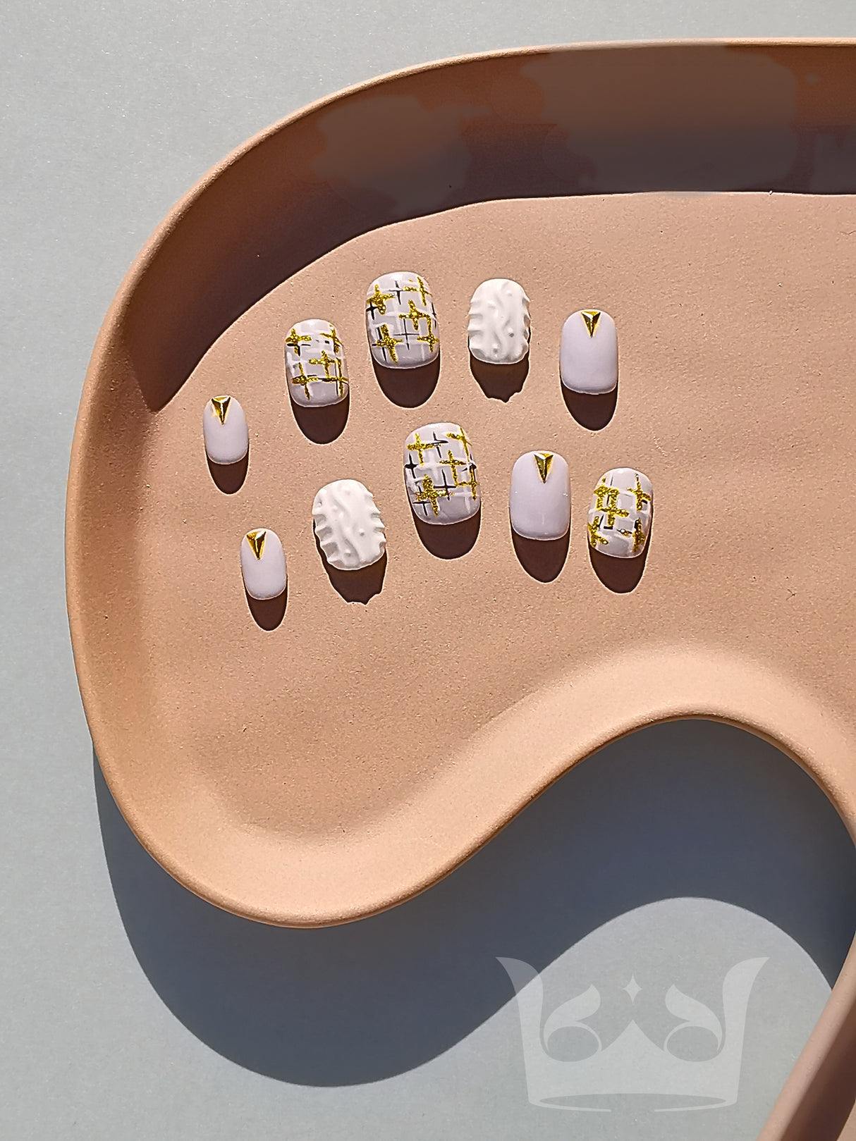 These press-on nails feature a modern twist on the classic French manicure with embellishments and geometric lines for a stylish look. Suitable for special occasions or everyday wear.