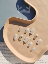 Ocean-inspired press on nails that is a minimalist and fancy design. Featuring blue diamonds and sculpted waves. Great for summer and vacation in 2024.