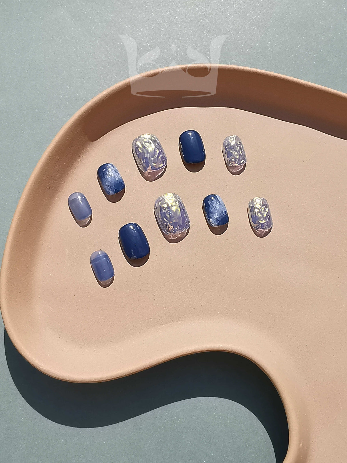 The image shows oval-shaped nails. The design elements include shape, color, and texture, creating a minimalist and elegant look.
