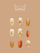 These press-on nails showcase elegant and feminine nail art with a playful touch, using warm colors, glitter, metallic flakes, bows, and animal silhouettes. 