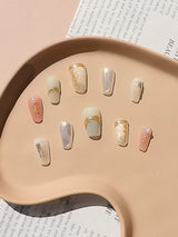 Luxury nails with neutral color scheme, gold accents, and elegant design for everyday wear or special events. Minimalist with a touch of luxury.