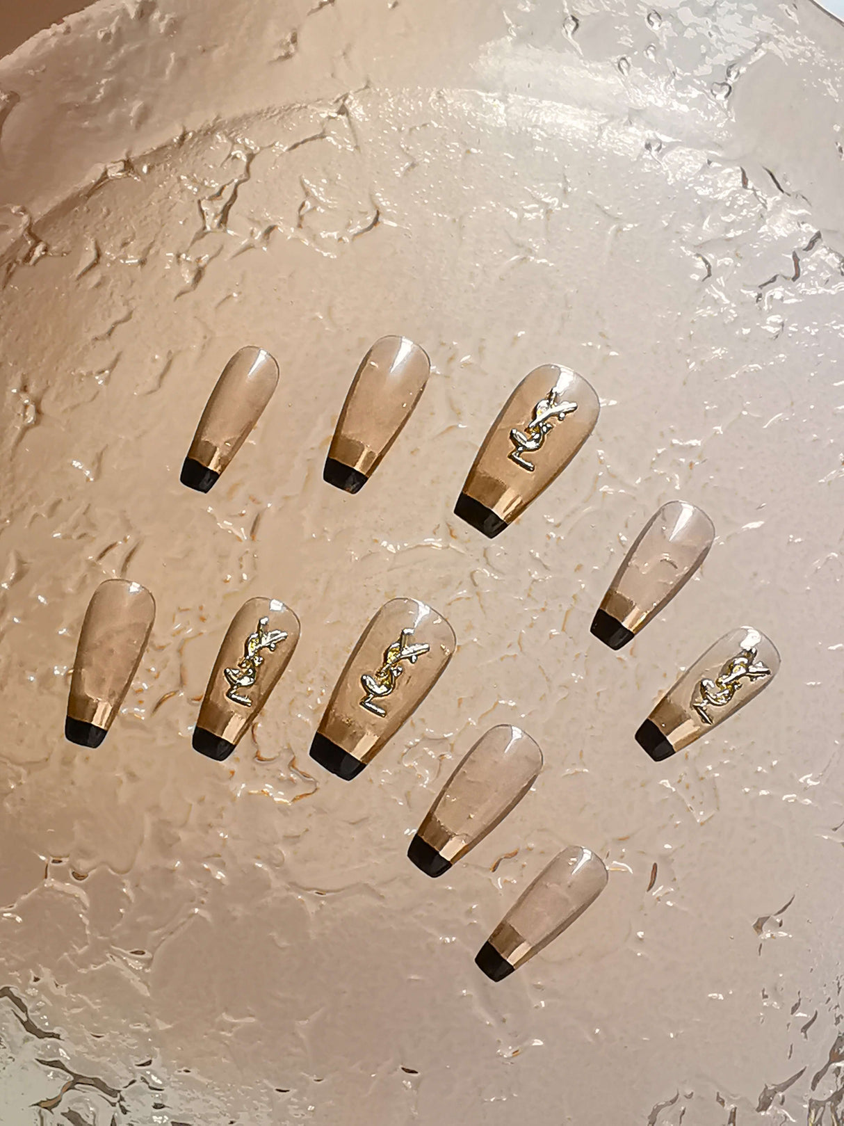 These press-on nails are perfect for special occasions or professional projects, featuring a French manicure style with black tips and trendy gold patterns for an elegant and luxurious look.