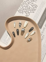 These press-on nails offer a stylish and contemporary look with a neutral color palette, chic patterns, and gold accents. They are suitable for various occasions.