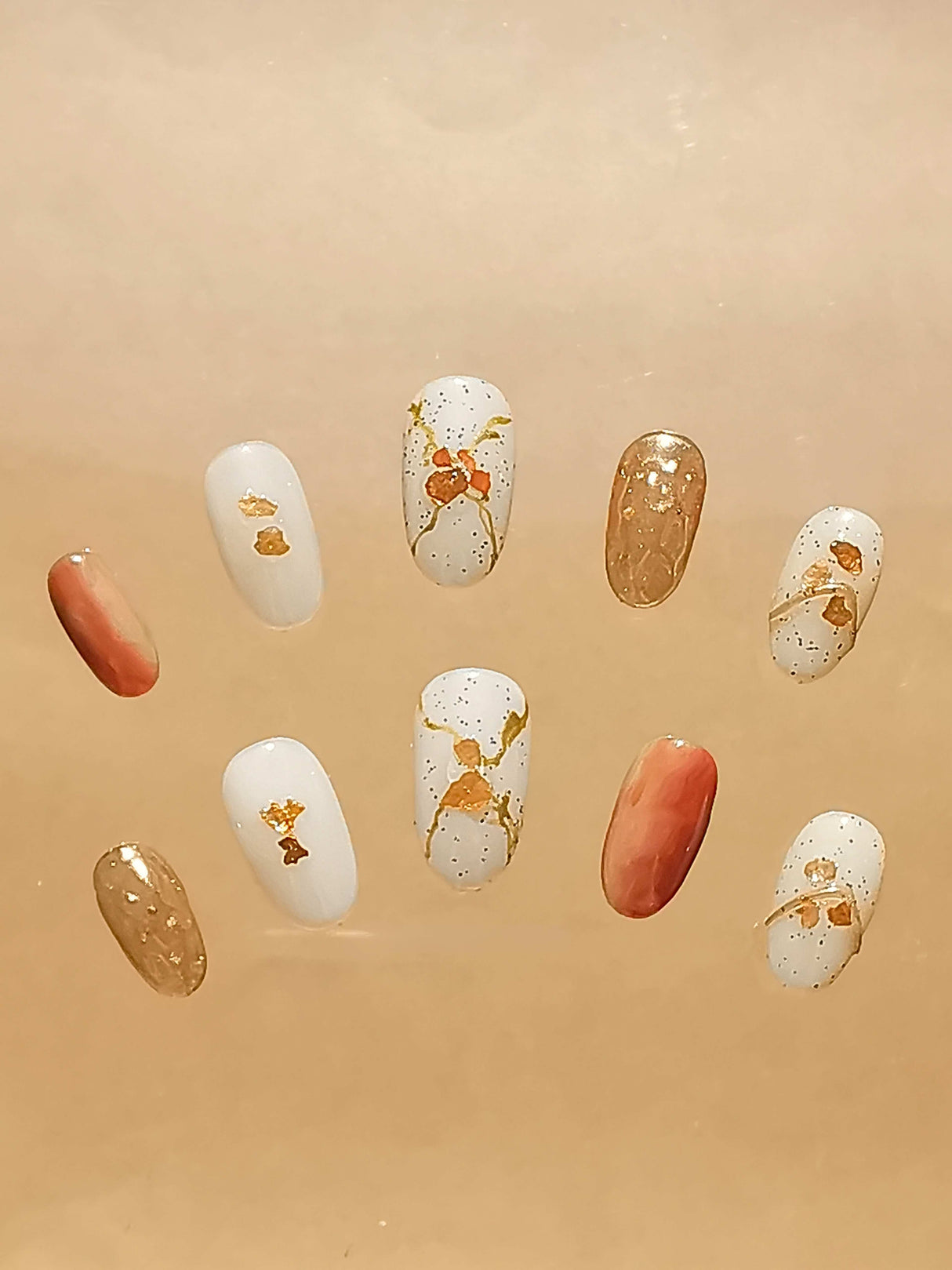 Fashionable and fancy nail art nails with color, pattern, and texture. Features solid and abstract designs with gold foil accents. A focus on elegance and luxury.