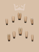 These press-on nails are  for special occasions, with consistent design and gold accents. They have a nude base, gold tips, and stylized gold designs.