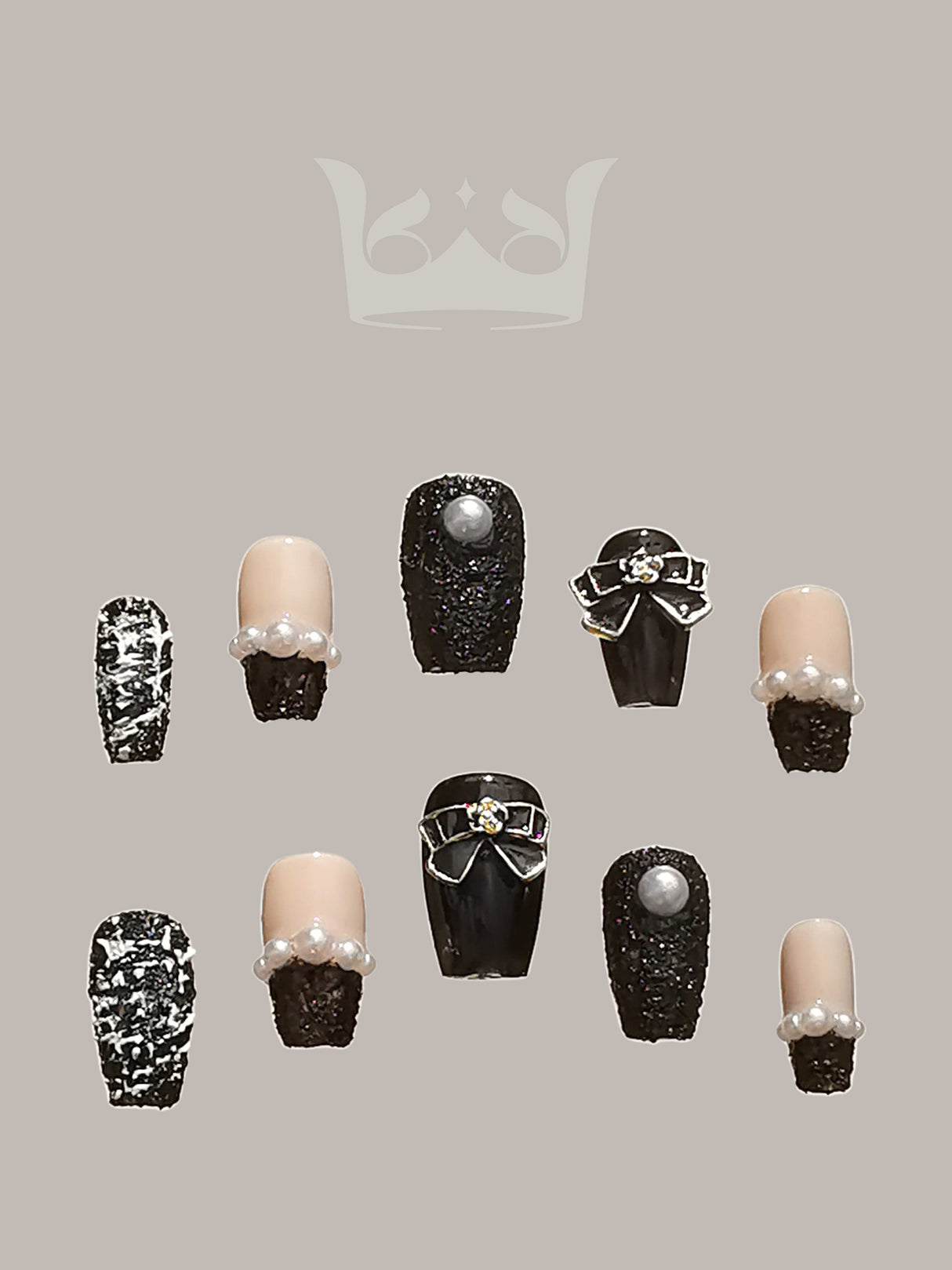 These press-on nails featuring a neutral base with textured black overlay, pearls, metallic accents, and 3D elements. The symmetrical design creates a luxurious and bold aesthetic.