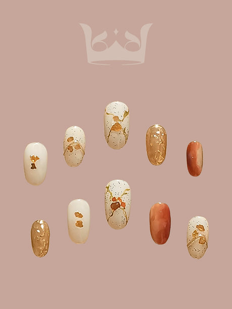 Fashionable and elegant nails with solid colors and gold accents, suitable for special occasions. Warm color palette and fancy look.
