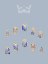 These nails featuring blue and silver colors, rhinestones, metallic accents, marble effect, abstract art, and a glossy finish. For those with a desire for bling, shine, and unique designs.