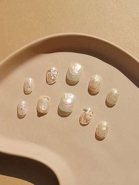 Sophisticated and opulent nails with rhinestones, pearls, metallic beads, and glitter for special occasions like weddings and parties. Elegant and glamorous.
