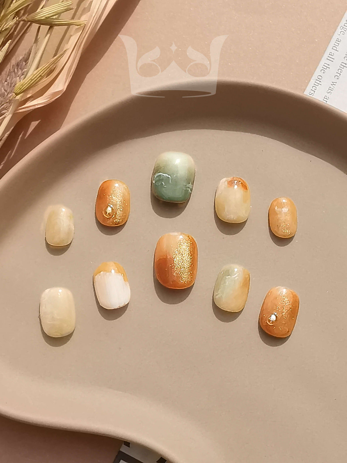 These press-on nails are for those who appreciate a natural and bohemian aesthetic. They feature warm, earthy colors with a marbling effect and gold foil accents. 
