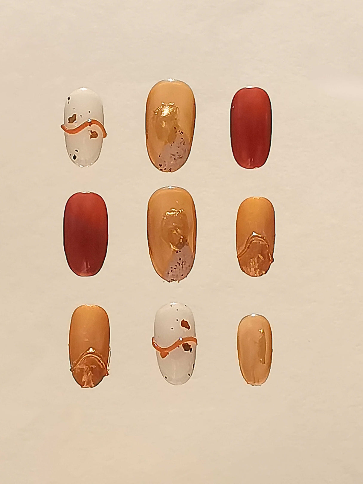 Cute nails for business casual, with playful designs including color, glossiness, glitter, irregular patches, and a small orange smiley face. Suitable for various occasions.