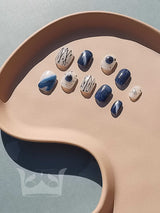 Fashionable nails with modern designs in blue, white, and gold/beige accents. Options for starry night, minimalist line art, or polka dots. Make a statement.