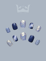 These press-on nails have a cool-toned, winter or water-themed aesthetic, featuring shades of blue, glitter, and marble-like patterns. Great for nail art inspiration.