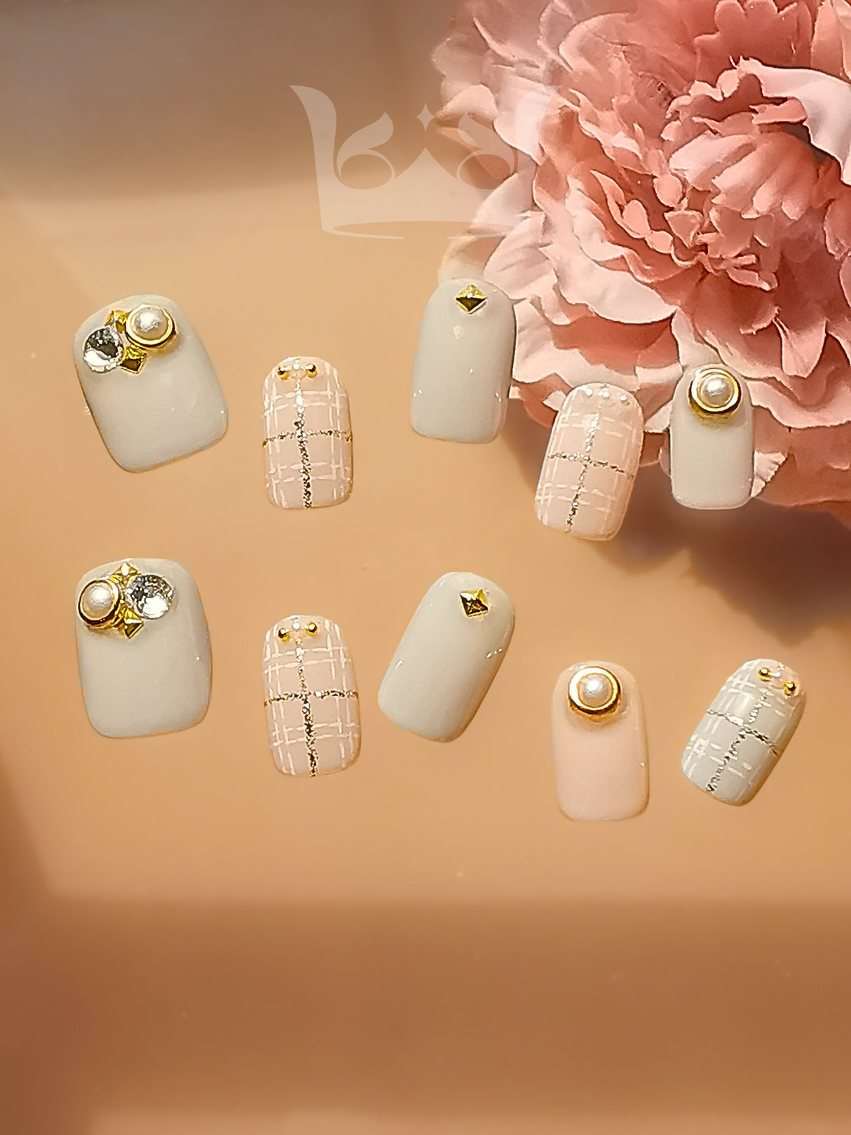 These press-on nails are meant for special occasions, with trendy designs and gold embellishments. The soft pastel base adds a feminine touch to the elegant and fancy overall design.