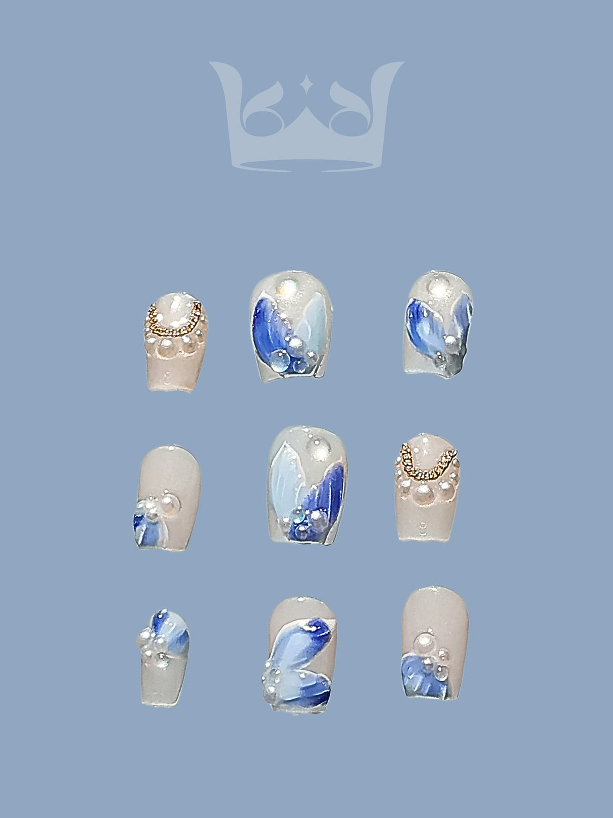 These press-on nails are for nail art with solid color backgrounds, marble-like patterns in blue and white, small gems, rhinestones, pearls, and a glossy finish. 