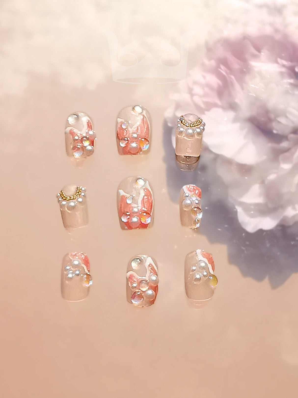 Cute nails with diamonds, gold bands, and clear/nude base for a fancy and personalized look. Ideal for special occasions and fashion statements.