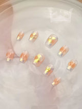 Luxurious and modern nails with gold foil or metallic leaf abstract pattern on clear/translucent base, presented delicately on water surface for special occasions or fashion statement.