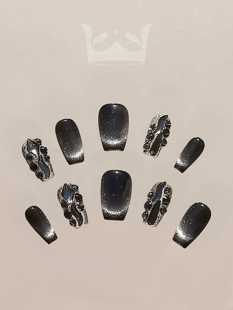 Glamorous and ornate nails with dark base color, glittery finish, silver metallic embellishments, and overall luxurious aesthetic for special occasions.