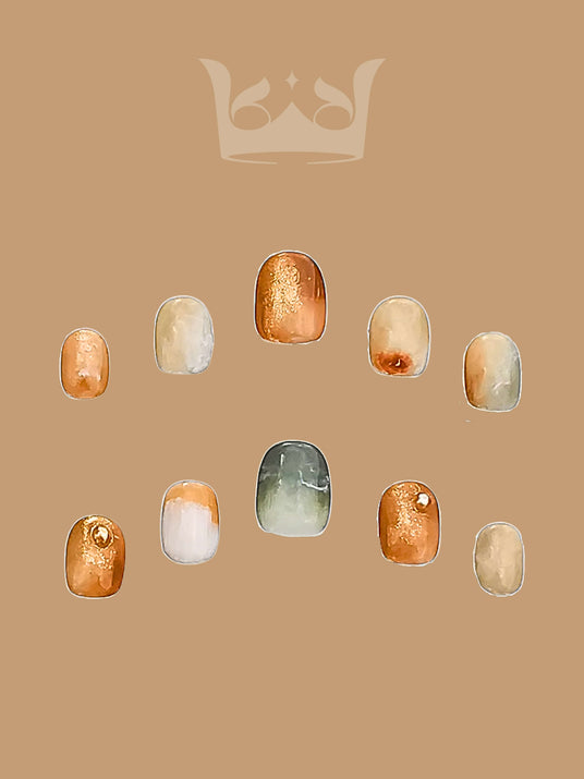 These press-on nails have a warm, earthy color palette with a marbled effect, glitter accents, ombre gradient, solid colors, and a glossy finish. They are inspired by stones and minerals.