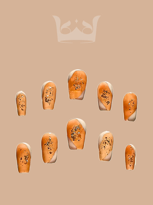 These press-on nails are for adding luxury and glamour to a manicure, with a nude base and gold flakes. They are  for special occasions or displays.