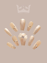 These versatile nails feature a neutral base, marble effect, rhinestones, accent nail, and glossy finish for a fancy and glamorous look. Suitable for everyday wear and special occasions.